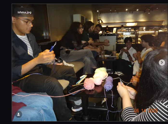 People knitting together around a coffee shop table
