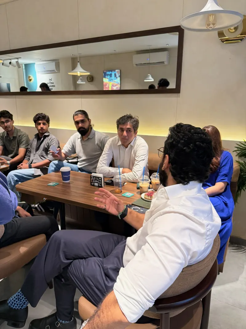 Guests at a long table listening to a speaker